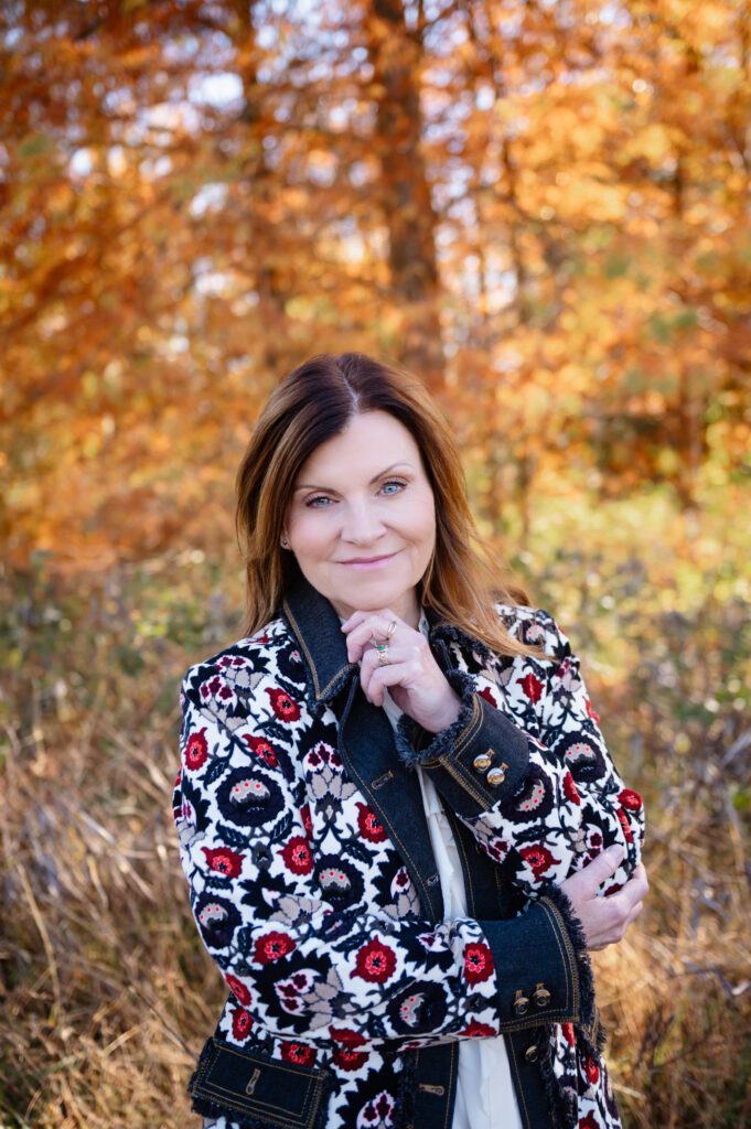 outdoor portrait with an outfit change, owner is facing the camera with her hand under her chin