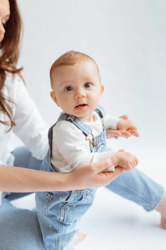 close up of infant daughter's face, she is holding her mom's hands, but the mom is in off camera