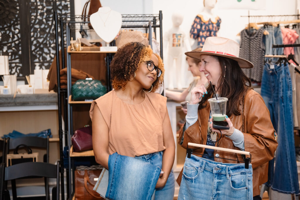 Two guests laughing and shopping together during the Hello Spring event at Bohemian Black boutique in Annapolis