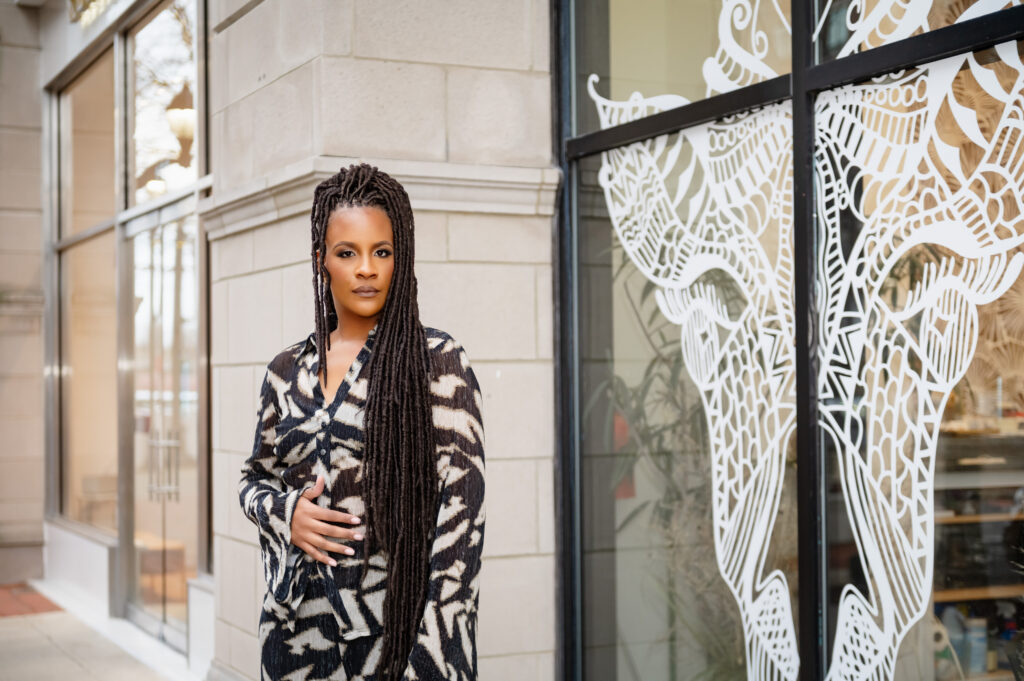 Local business photographer features Rose owner of Bohemian Black standing outside her boutique at Annapolis Town Center in a zebra print suit