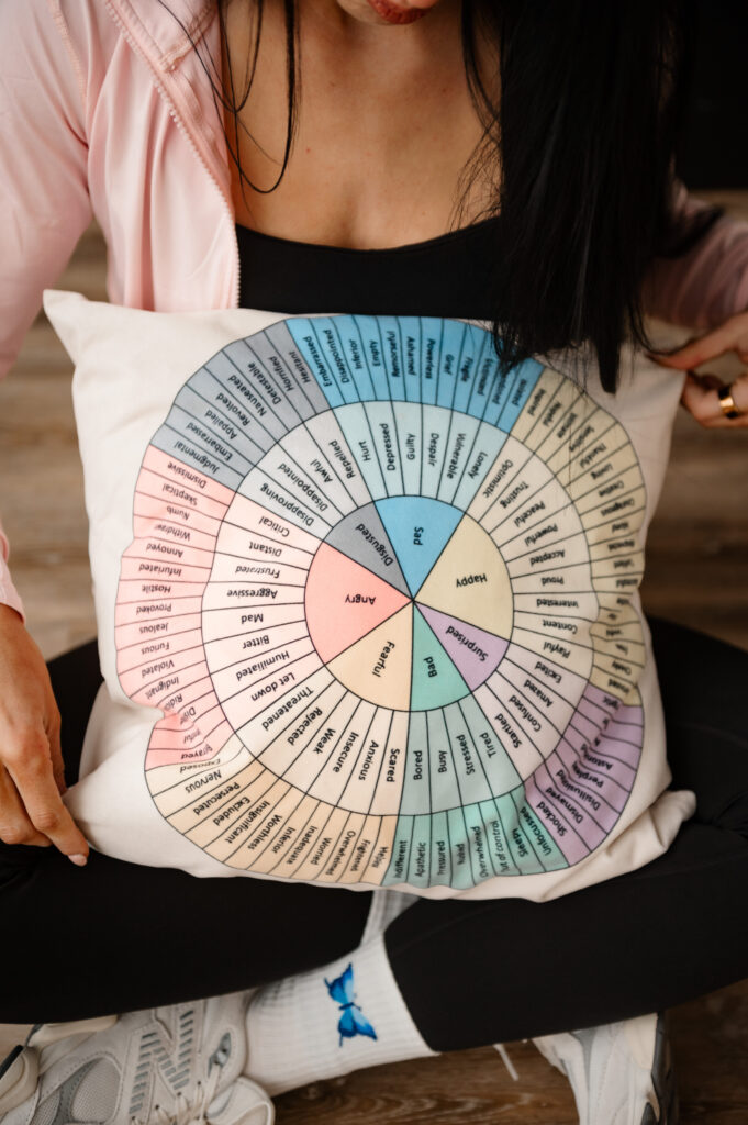 Annapolis MD brand photographer captures therapist holding emotions wheel pillow during brand session